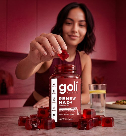Woman placing a Goli Renew NAD+ gummy into a bottle in her kitchen