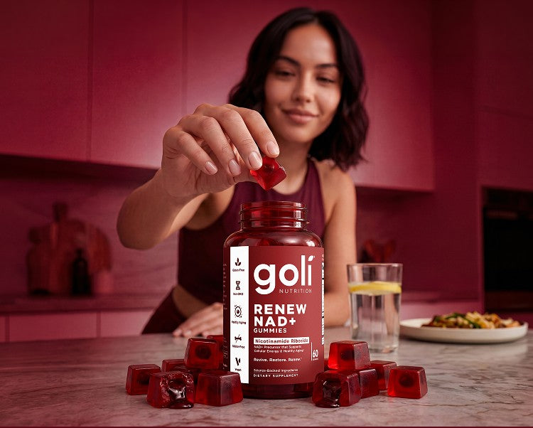 Woman placing a Goli Renew NAD+ gummy into a bottle in her kitchen